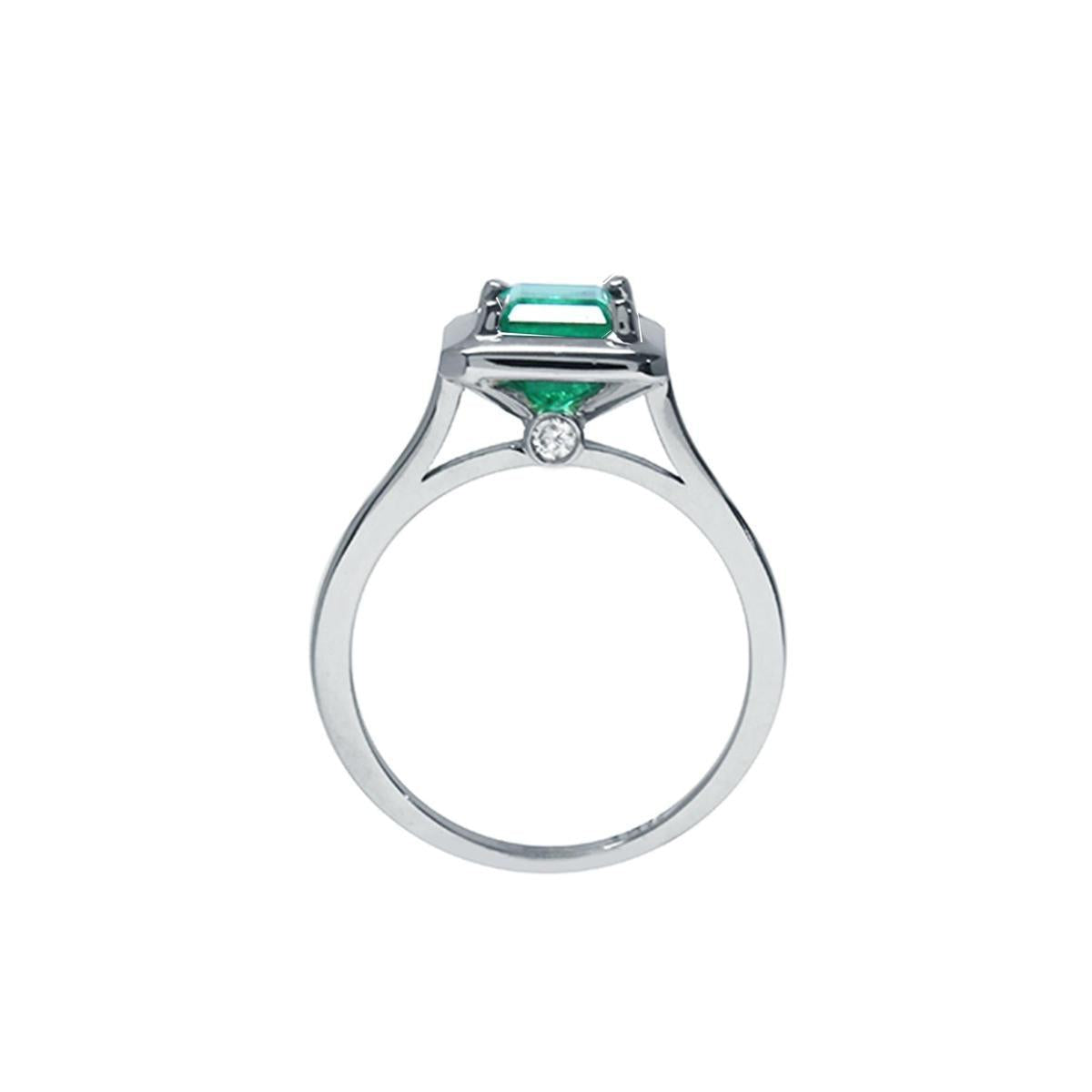 A lateral view of this solitaire emerald ring shows the setting, gallery and band, including the Centinel diamond.