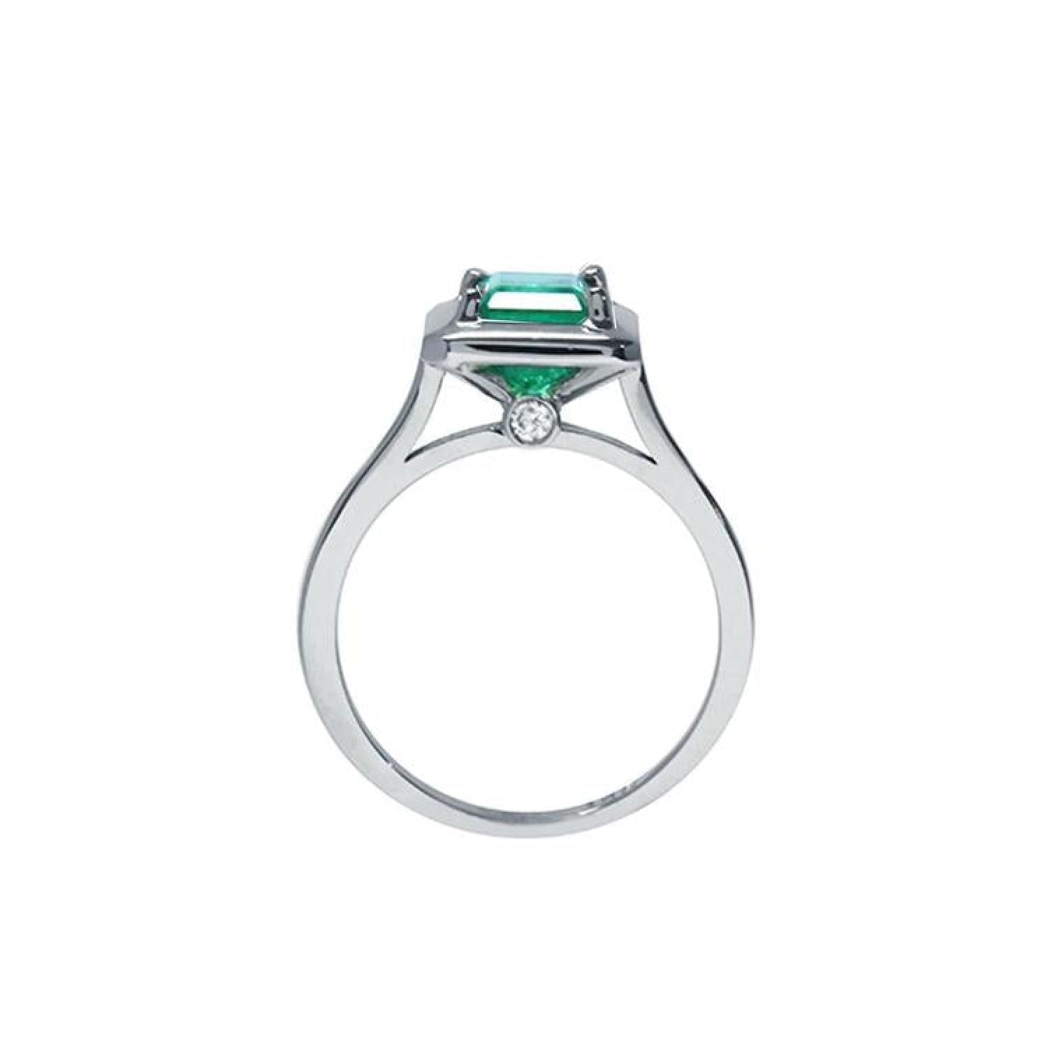 1.50 carat Muzo Colombian emerald solitaire ring in 18K white gold with a small diamond accent.
