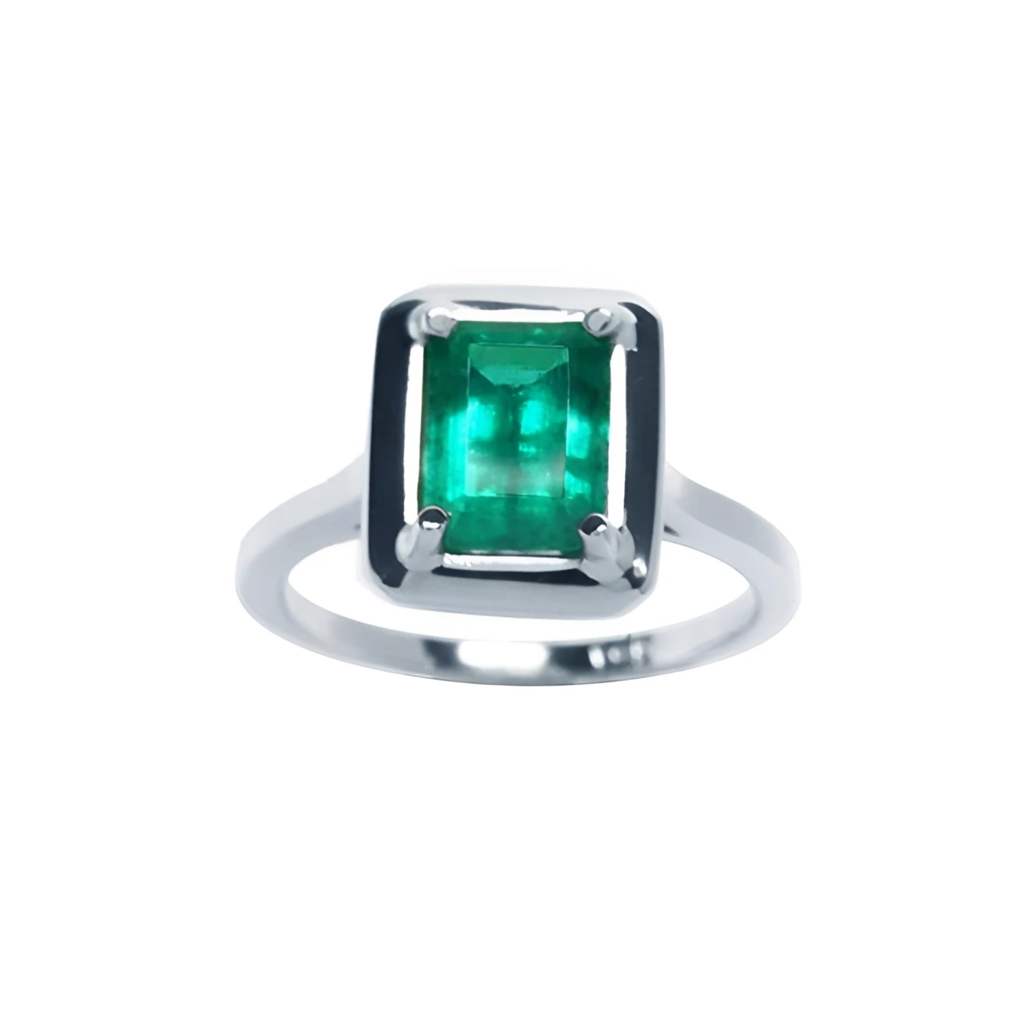 This Muzo Colombian emerald solitaire ring features a rectangular emerald-cut stone set in prongs of 18k white gold.