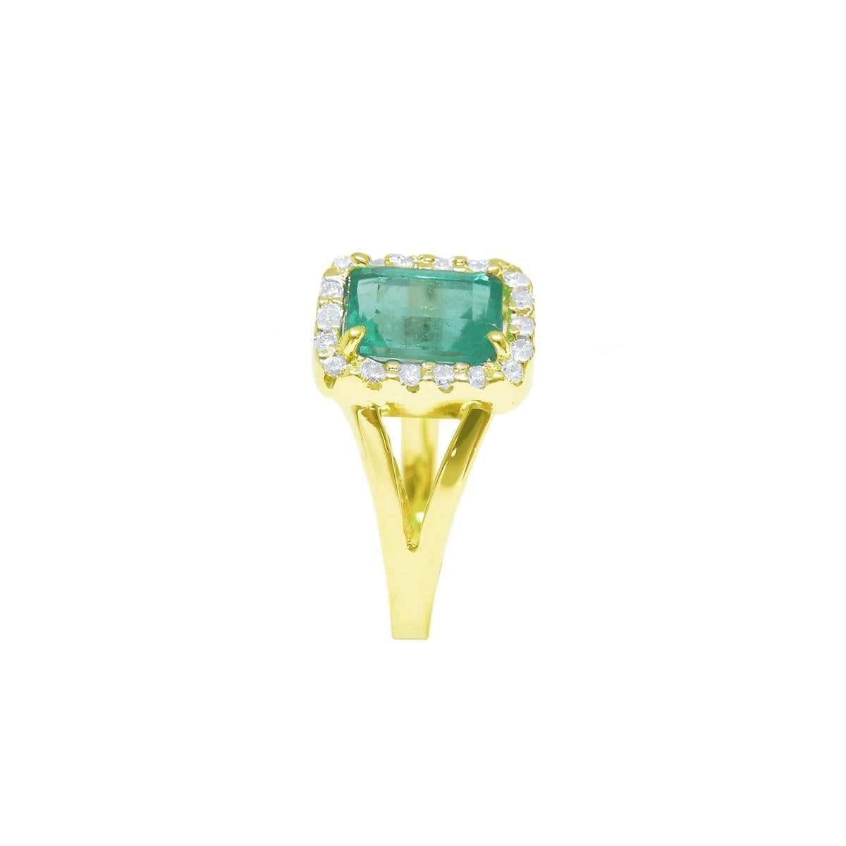 A side view of a natural emerald and diamond ring yellow gold/