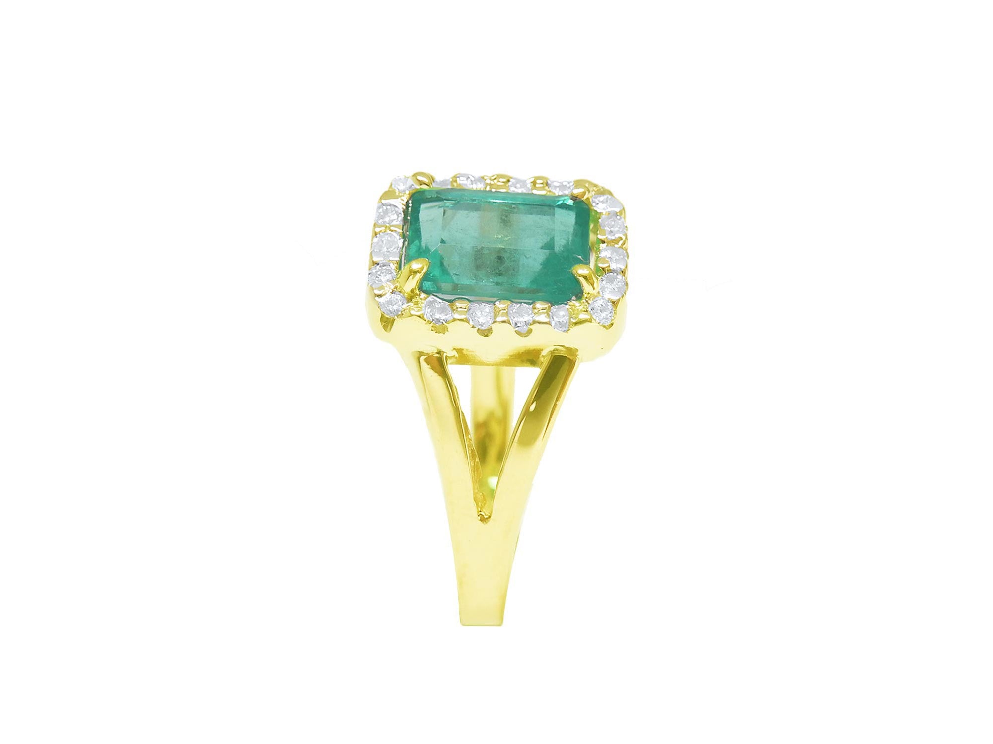 A side view of a natural emerald and diamond ring yellow gold/