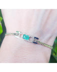 A bracelet with a natural Colombian emerald sourced from the Muzo mines very good quality, made in 14k yellow gold on a wrist.