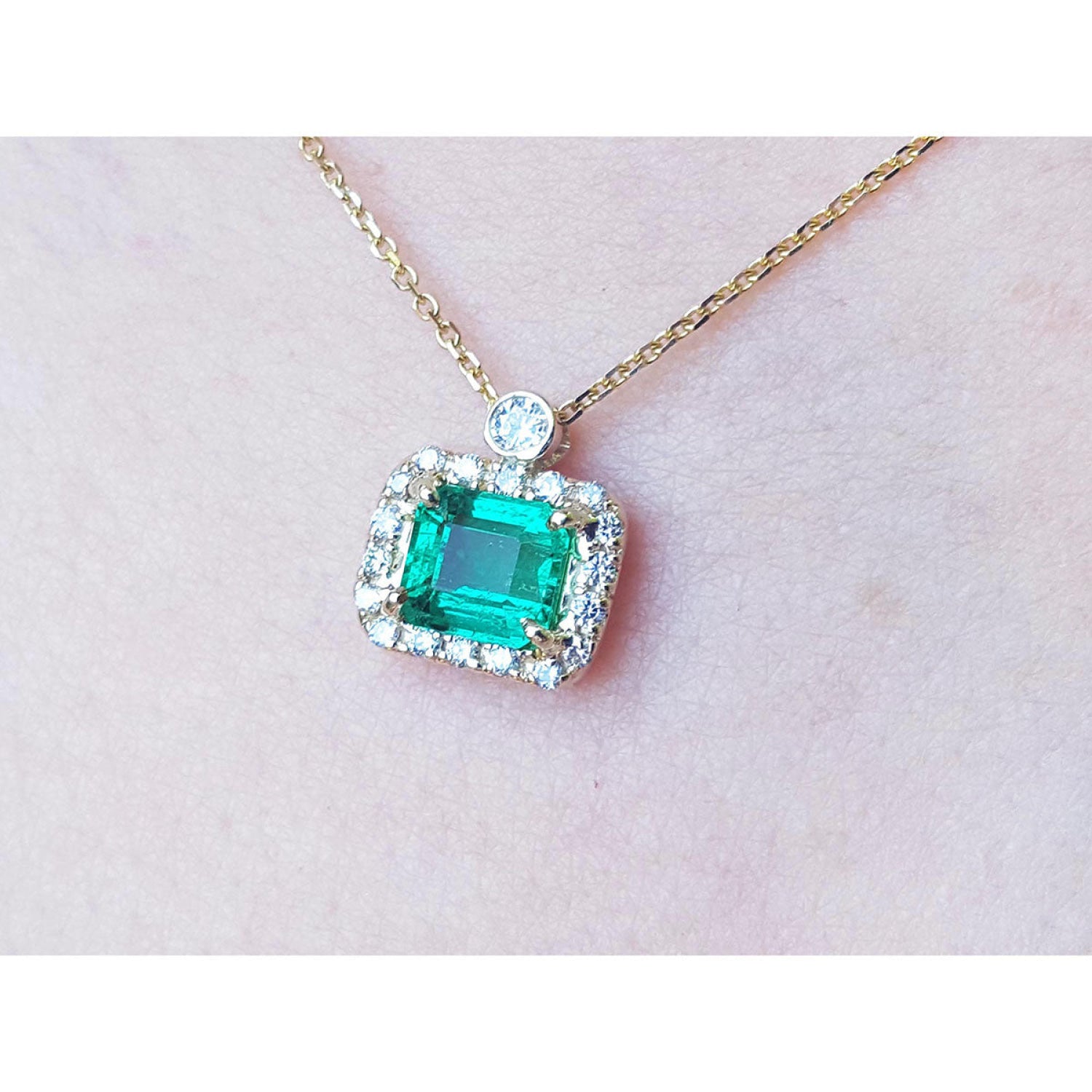 1.31 ct emerald-cut Muzo Colombian emerald necklace with diamonds in 14K yellow gold.