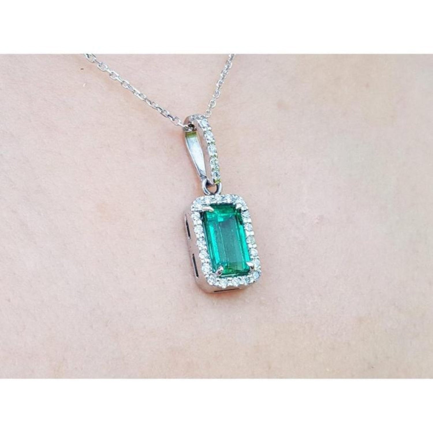 1.70 ct. Muzo Colombian emerald pendant with diamond halo on an 18K white gold chain.