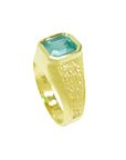 The half side position of this yellow gold emerald solitaire ring for men shows the top bezel setting and band design.