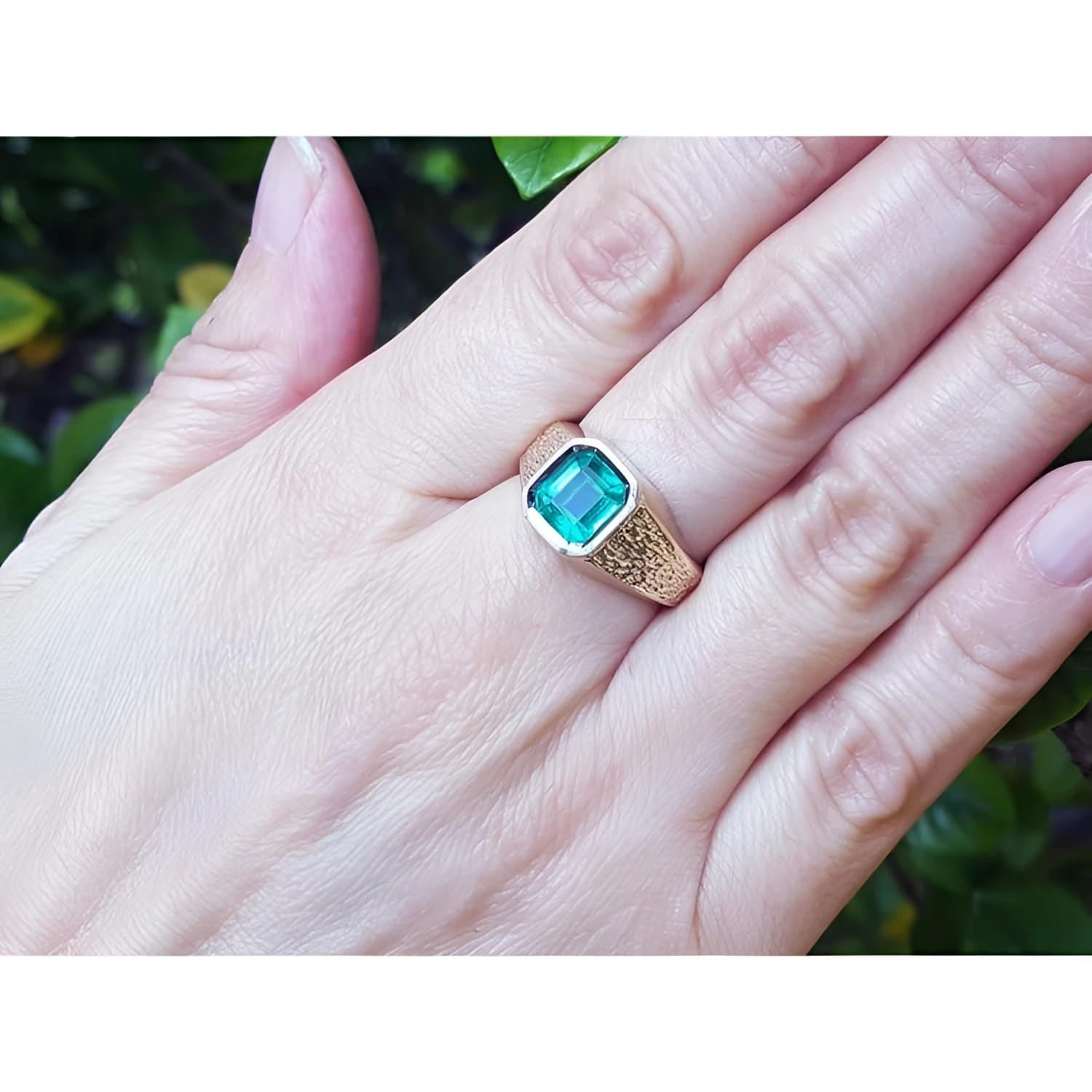 Men's 14K yellow gold ring with a rectangular emerald-cut bluish-green Colombian emerald, bezel set.