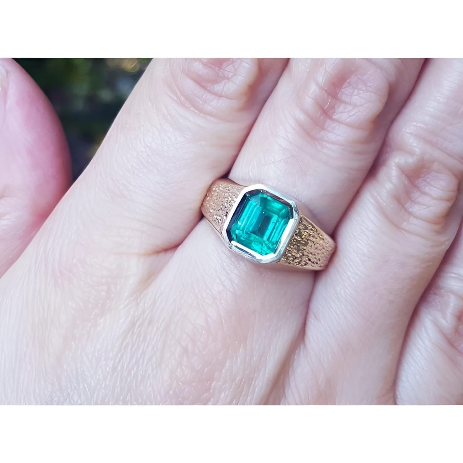 Men's 14K yellow gold ring with a rectangular emerald-cut bluish-green Colombian emerald, bezel set.