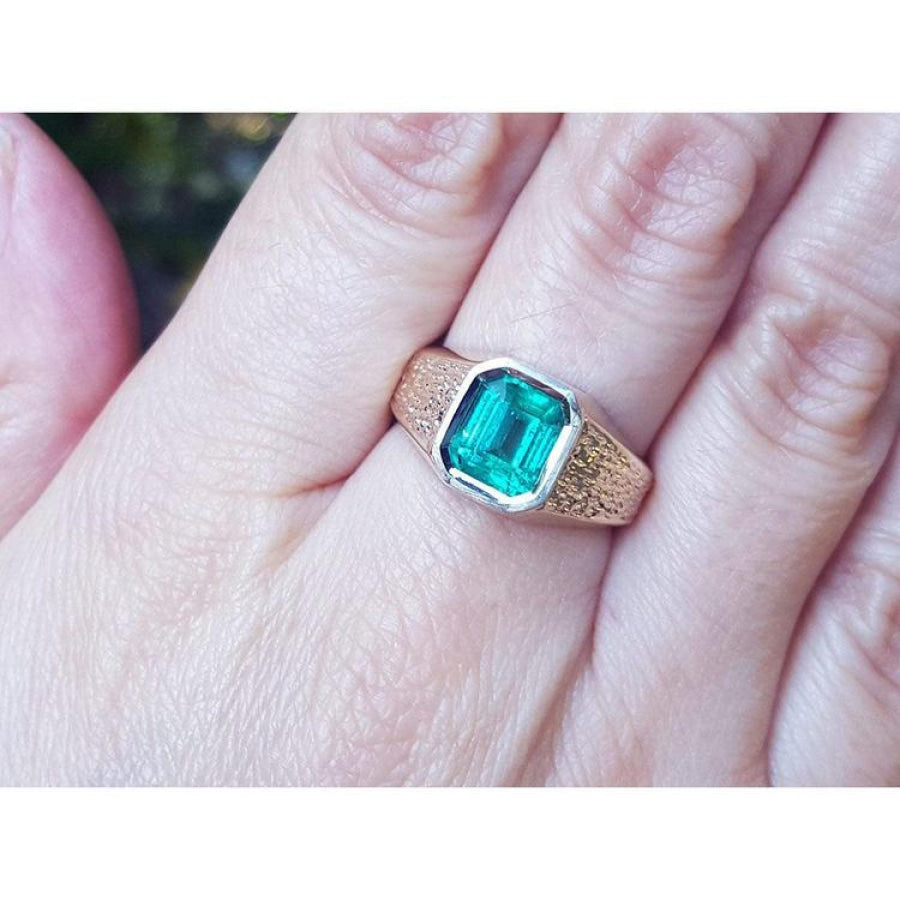 Men's 14K yellow gold ring with a rectangular emerald-cut bluish-green Colombian emerald, bezel set.