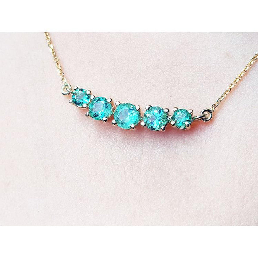 14K gold necklace with five round, medium light green Colombian emeralds, graduated in size.