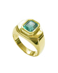 The tilted position of this yellow gold mens emerald ring displays the top bezel setting and a partial sides perspective.