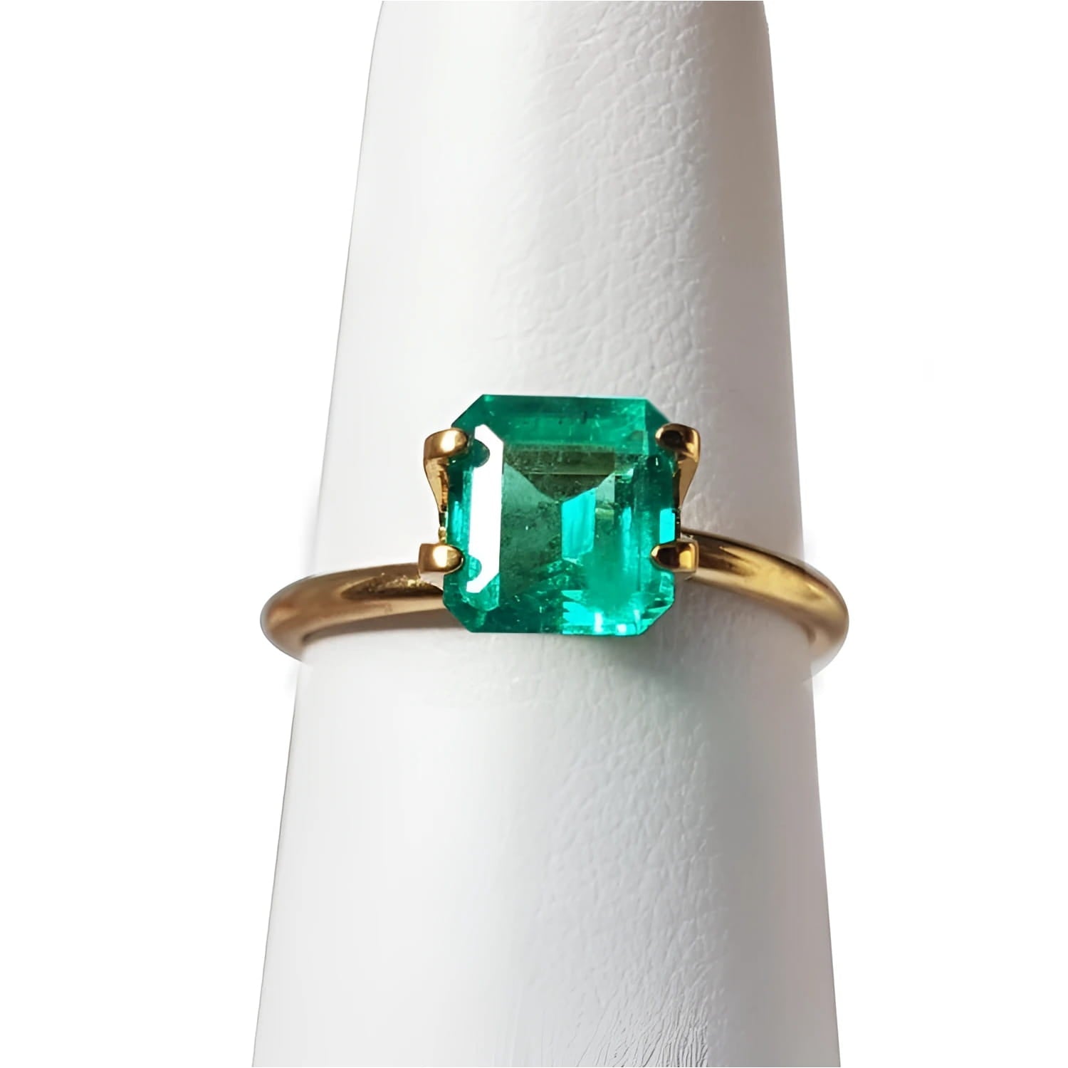 1.28 carat emerald-cut Muzo Mine Colombian emerald in a simple gold ring setting.