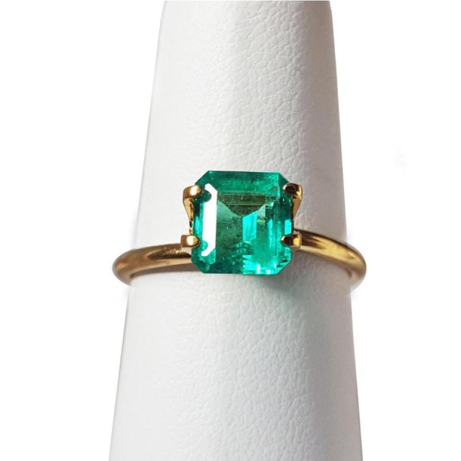 1.28 carat emerald-cut Muzo Mine Colombian emerald in a simple gold ring setting.