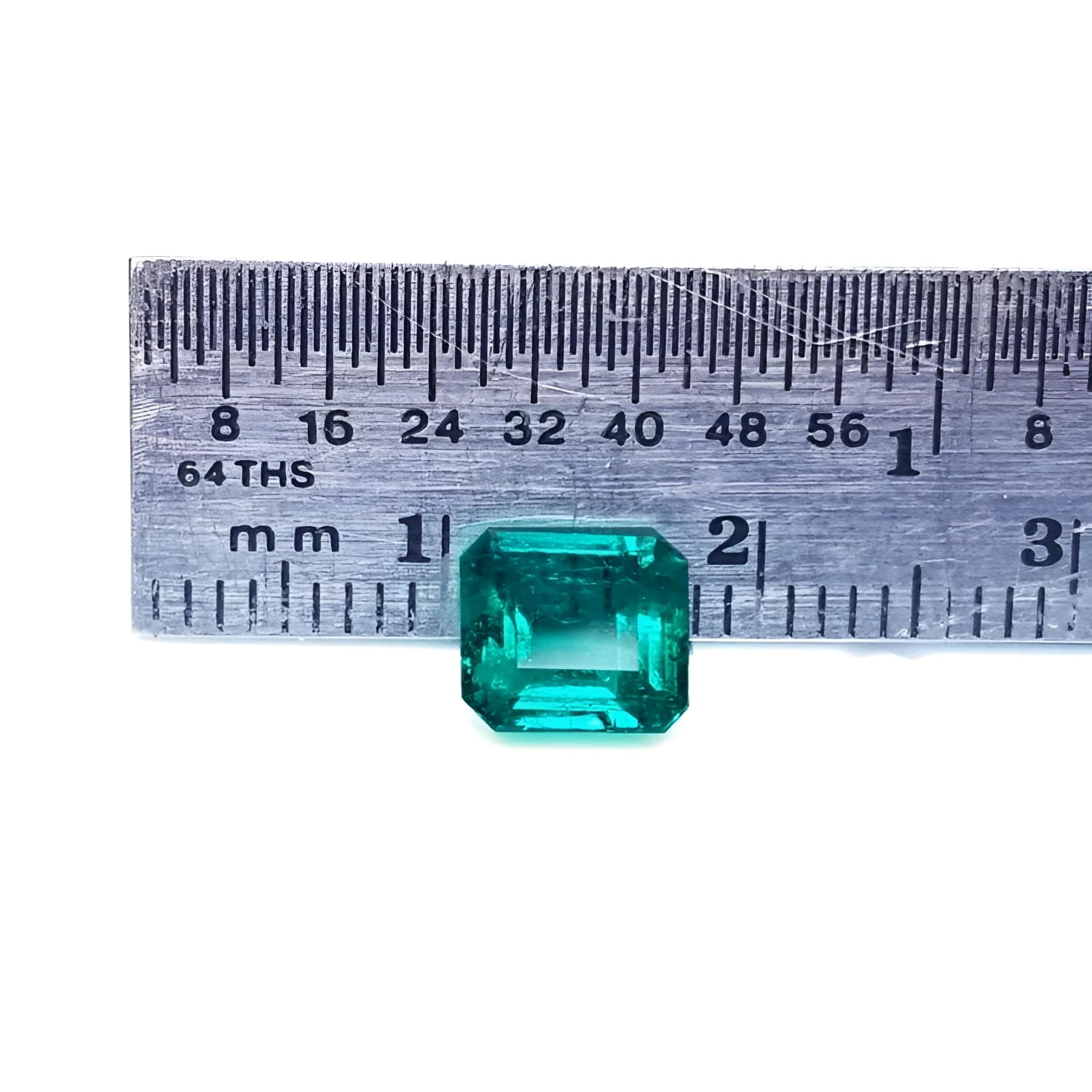 1.28 carat emerald-cut Muzo Mine Colombian emerald, medium deep bluish green, shown with a ruler.