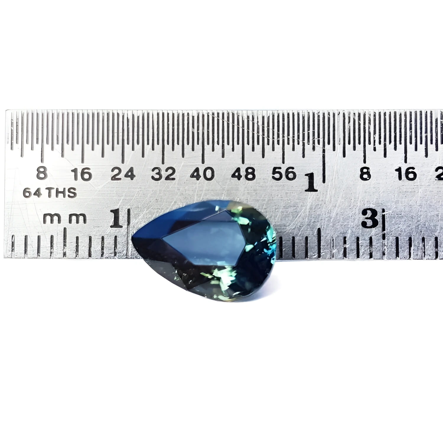 3.22 ct. pear-shaped Australian blue sapphire with deep blue-green hue, shown next to a ruler.