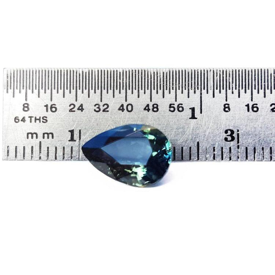 3.22 ct. pear-shaped Australian blue sapphire with deep blue-green hue, shown next to a ruler.