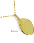 The backside closed setting in yellow gold on a chain of an opal pendant.