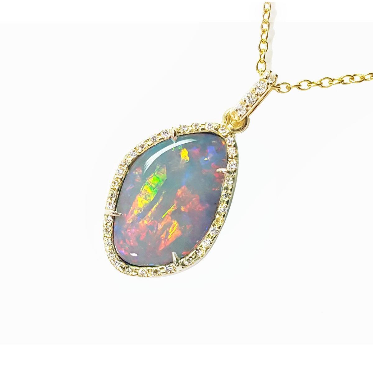 Opal pendant necklace with gold chain on a left side profile view.