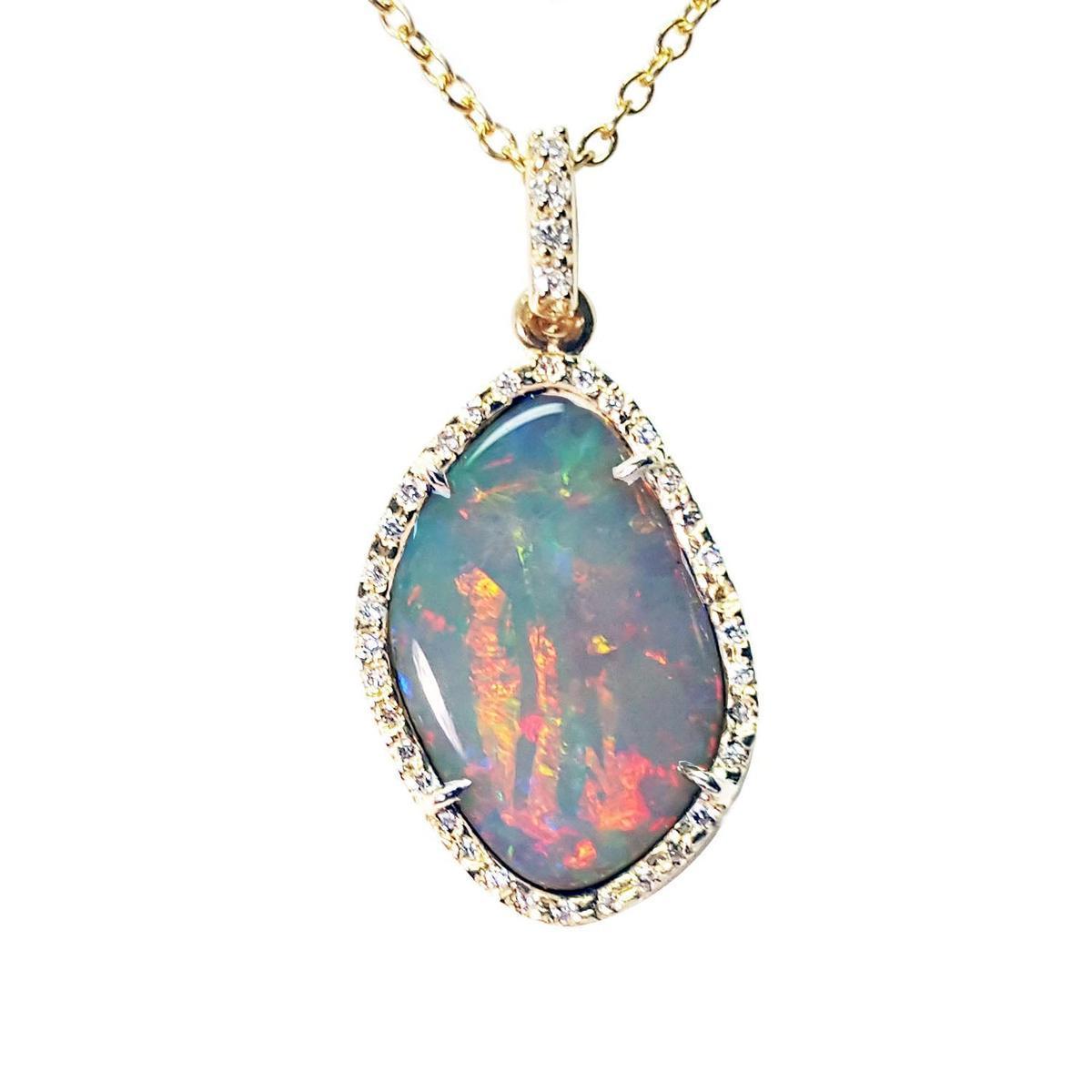A natural Australian solid opal red fire encased in a gold and diamonds frame on a gold chain, topside view.