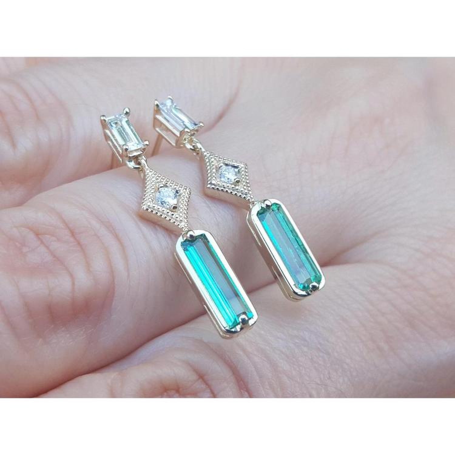 14K gold baguette cut emerald drop earrings with sparkling diamonds.