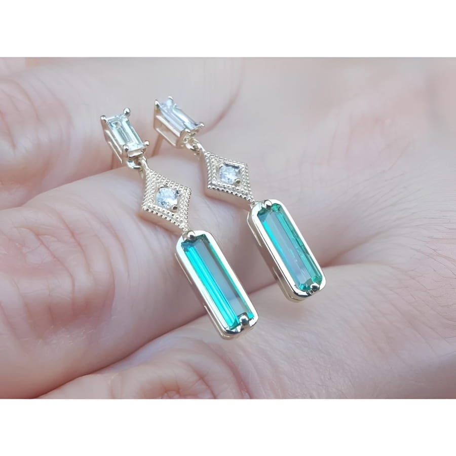 14K gold baguette cut emerald drop earrings with sparkling diamonds.