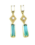 14k yellow gold earrings with baguette cut emeralds dangling from diamonds, front position top view.