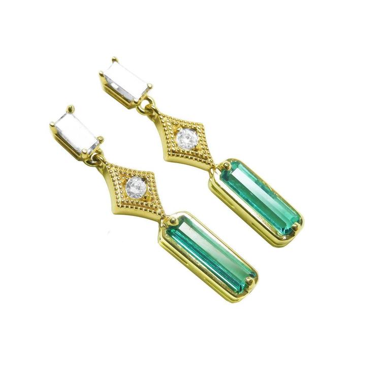 A pair of baguette cut natural emerald and diamond earrings, crafted in 14k yellow gold.