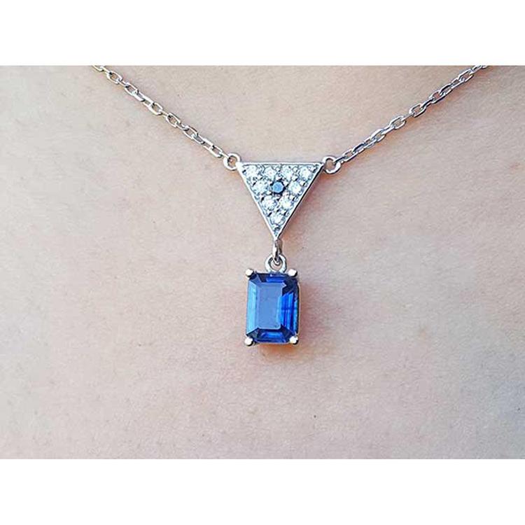 Necklace with a blue natural blue sapphire pendant on a plain background