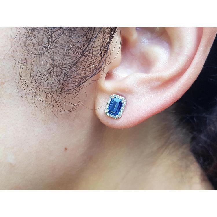  Natural blue sapphire stud earrings emerald cut halo diamond 14k white gold, close-up on ear