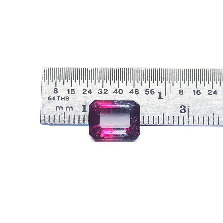 Natural 3.55 ct. watermelon tourmaline, vibrant red and greenish-blue, emerald cut, next to a ruler.