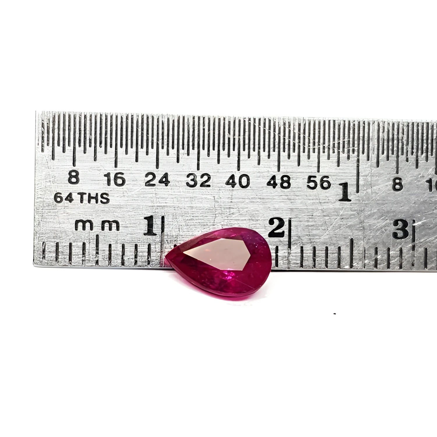 1.24 carat natural Burmese ruby, pear cut, brilliant medium red, shown next to a ruler.