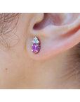 Close-up of an ear wearing a pink cabochon pink sapphire earring in 14k white gold.
