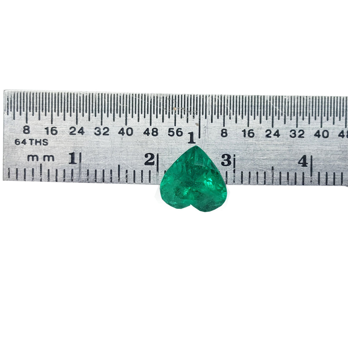 Heart cut natural colombian emerald next to a ruler.
