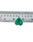 Heart cut natural colombian emerald next to a ruler.