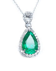 Teardrop-shaped emerald pendant into a halo diamond made in 18k white gold topside view.