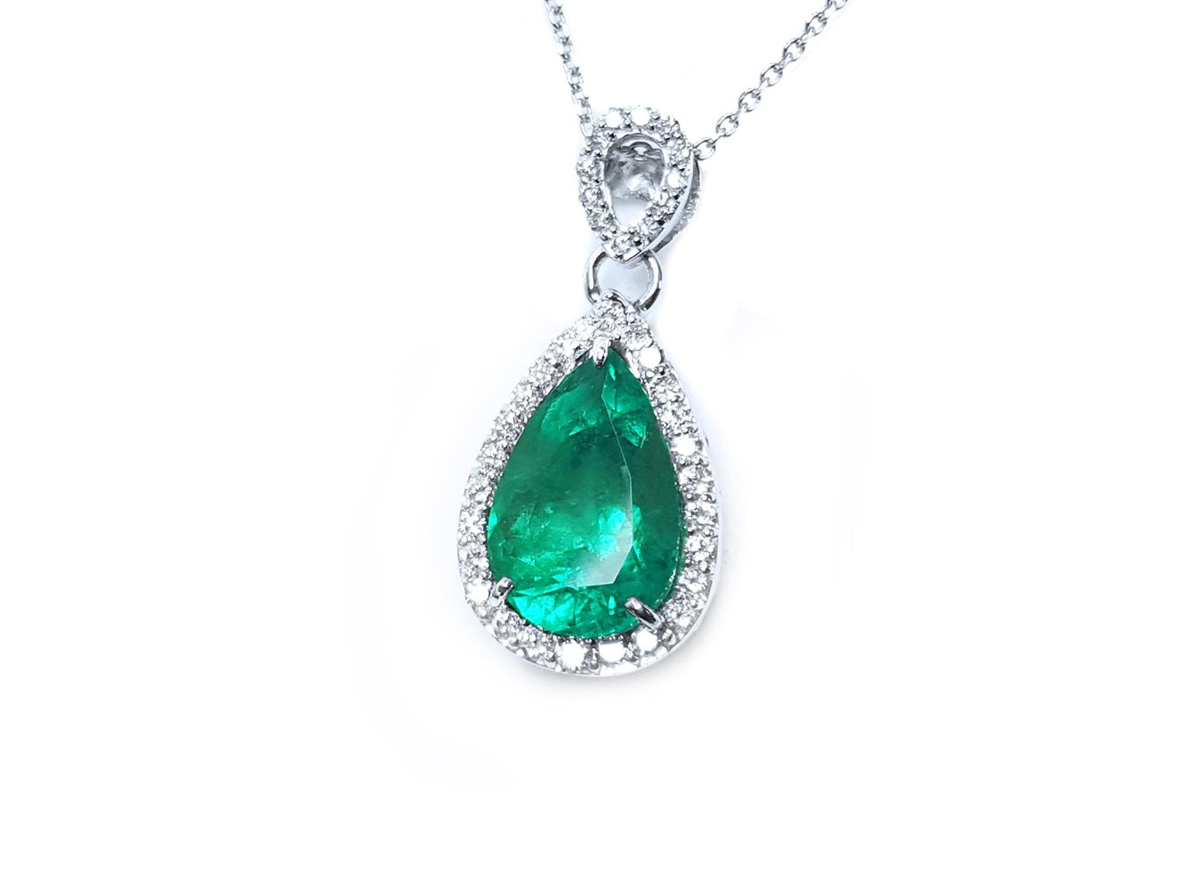 Emerald teardrop pendant with diamond accents on a plain topside visible.