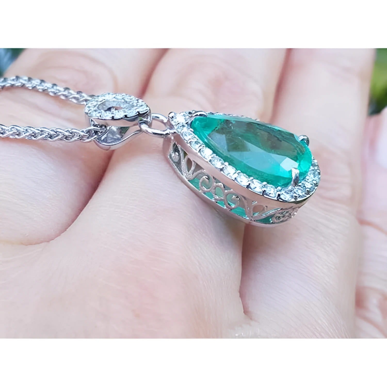 5.83 ct. Colombian emerald pear cut pendant with diamond halo, set in 18K white gold.