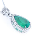 Emerald green teardrop pendant with white gold chain on a right side position topside and gallery visibles.