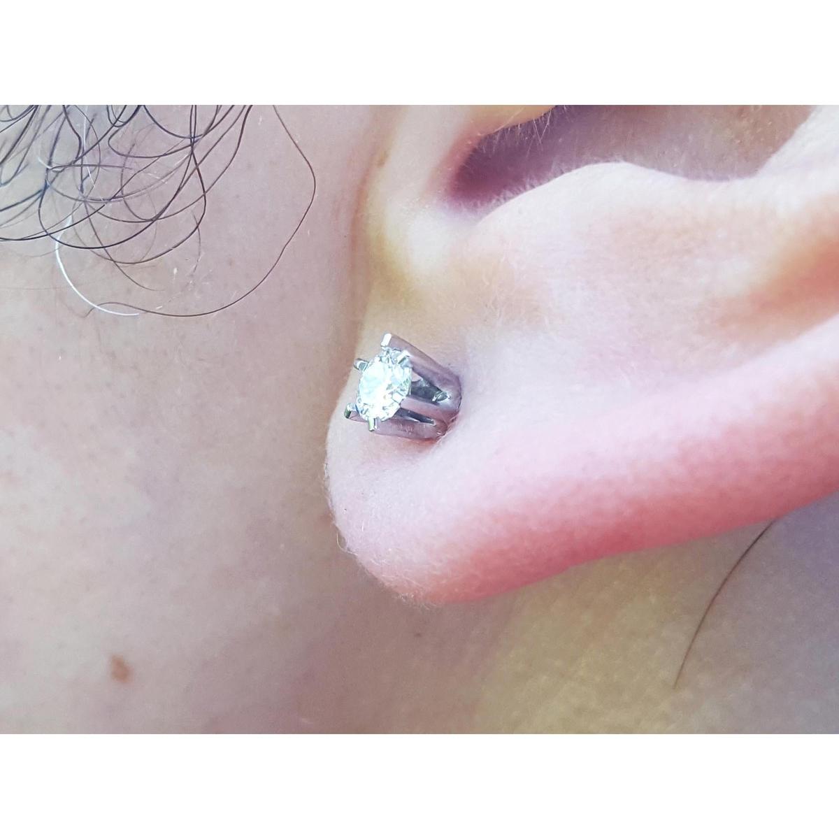 Close up of a 14k white gold diamond stud earring screw back on earlobe.