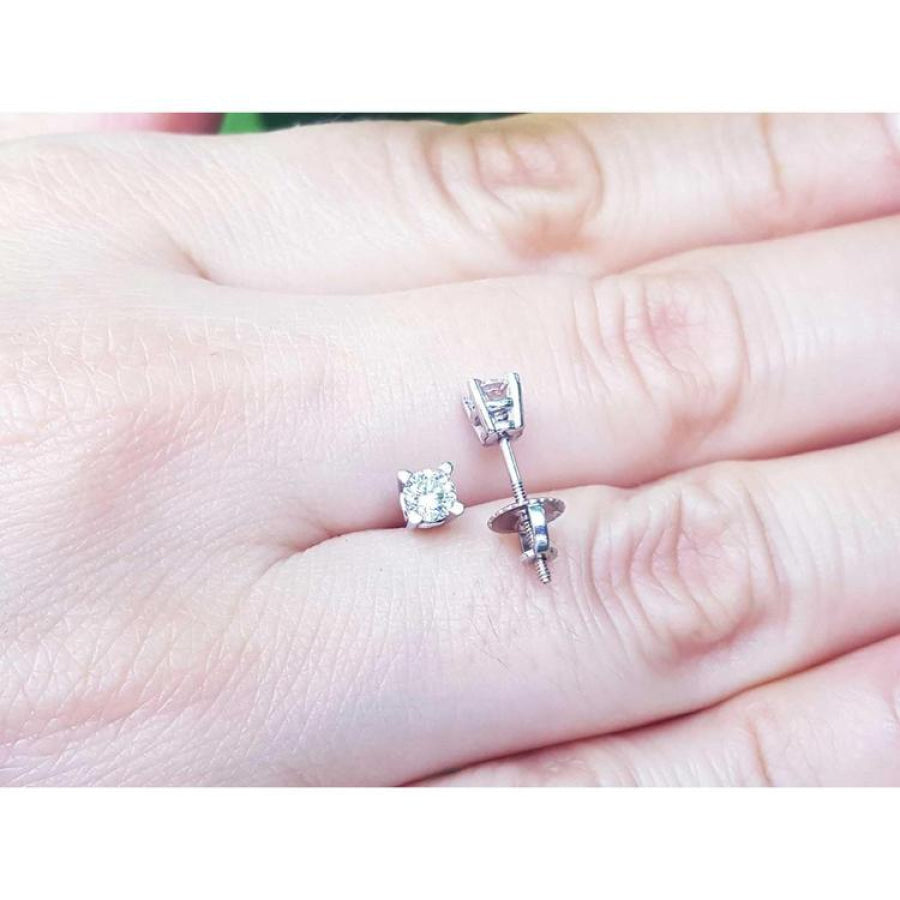 0.46 ct natural diamond stud earrings with screw backs, set in 14K white gold on a hand.