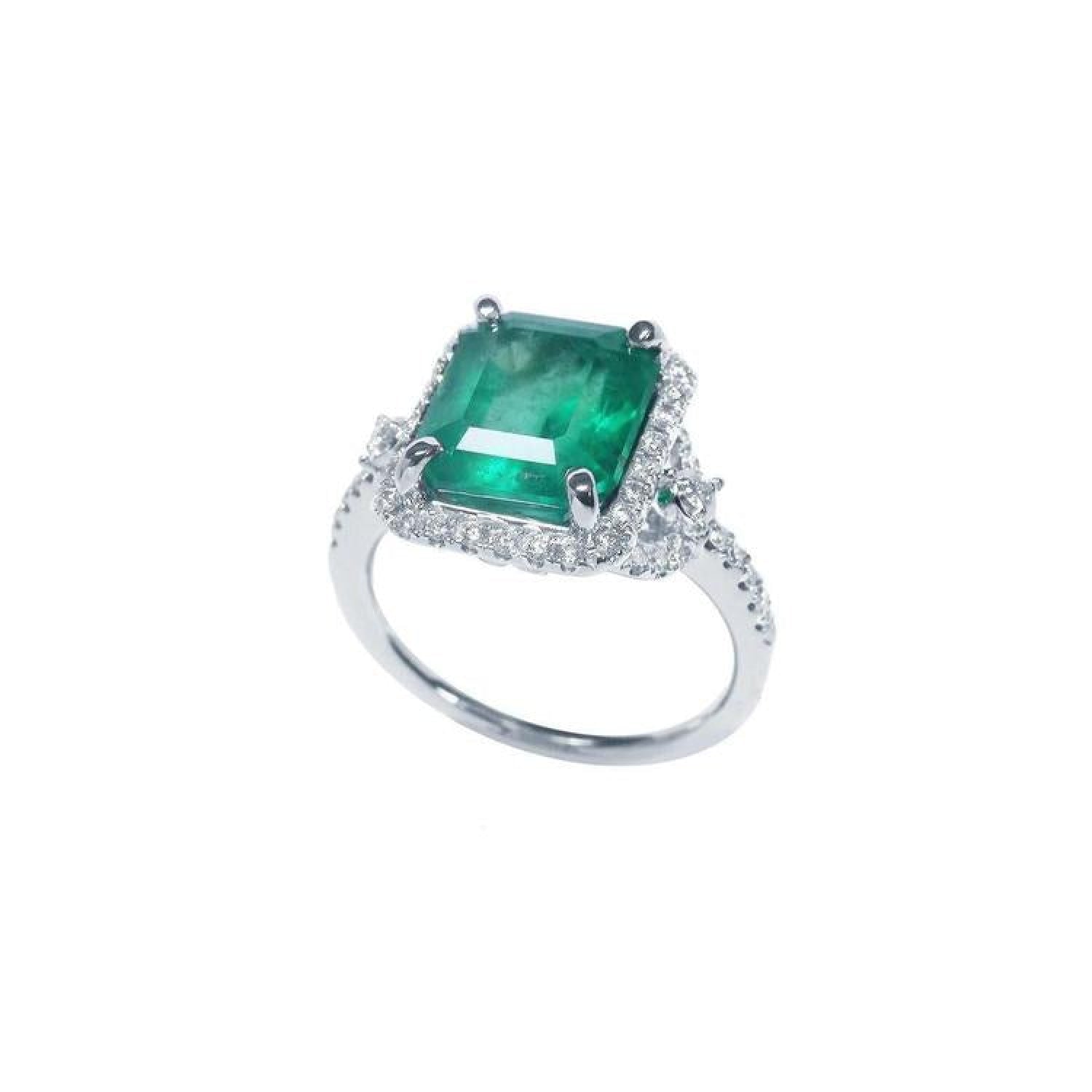 Emerald-cut natural Colombian emerald ring with diamond halo and band in 14k white gold.