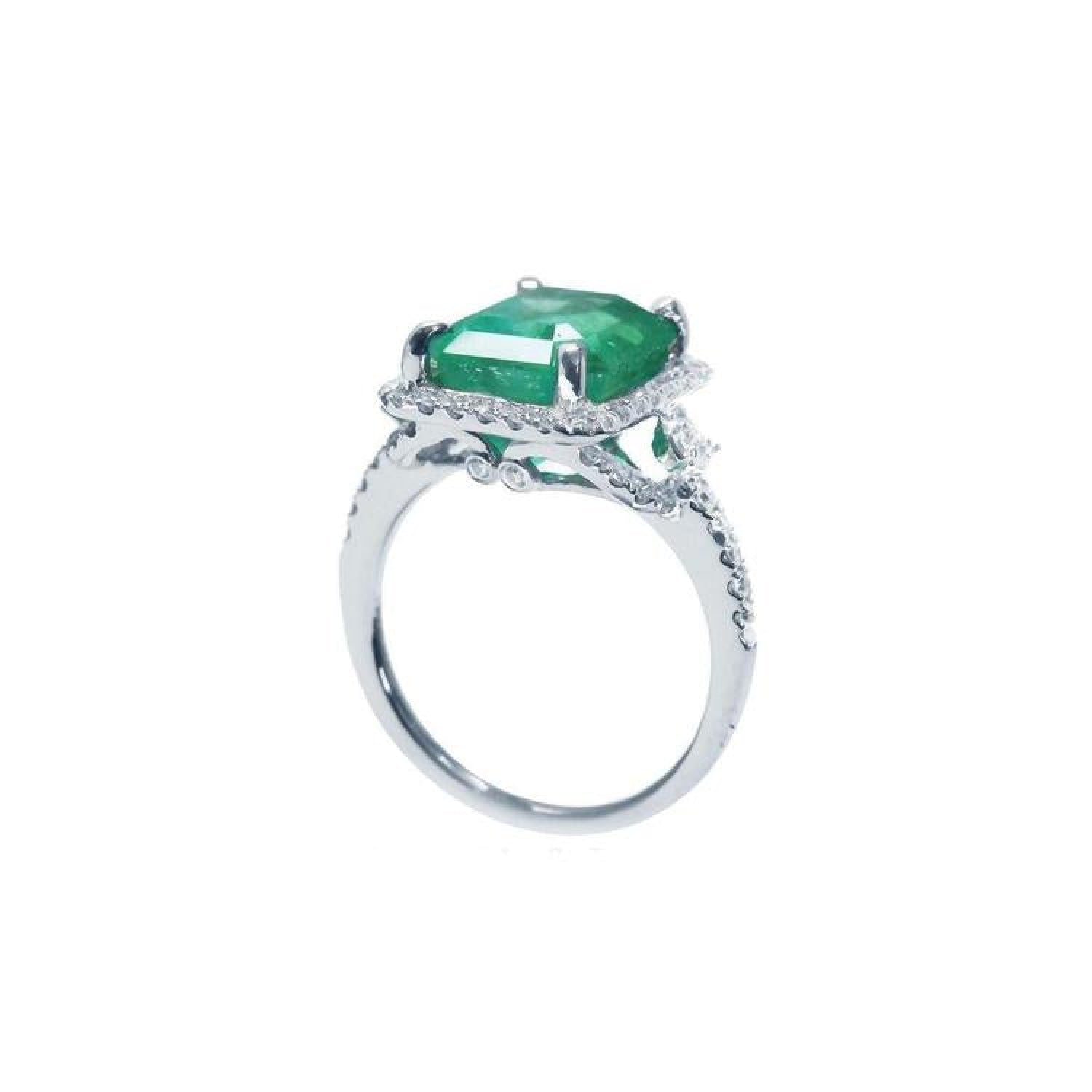 Emerald-cut natural emerald engagement ring in 14k white gold with diamond halo.