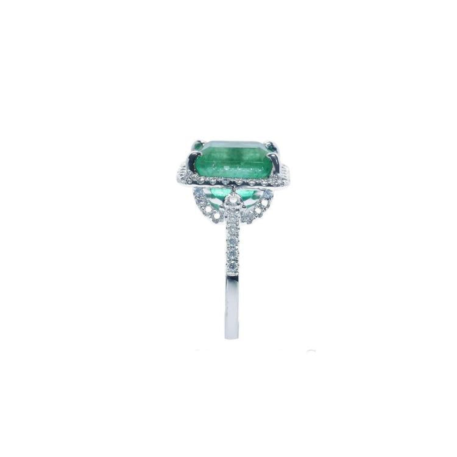Emerald-cut natural emerald ring with diamond halo and diamond-set 14k white gold band.