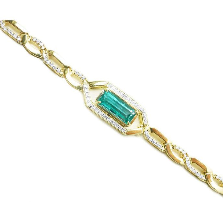 Gold bracelet with a baguette cut natural emerald, a unique design with accent natural diamonds, crafted in 14k yellow gold.