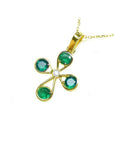 18K yellow gold cross pendant with four round Colombian emeralds and a central diamond.