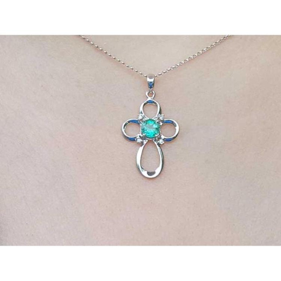 14K white gold cross pendant with a round Colombian emerald and diamond accents on a chain.