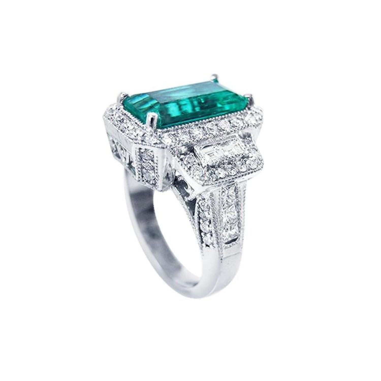 18K white gold ring with a vibrant emerald-cut Colombian emerald, haloed by diamonds and baguette side stones.