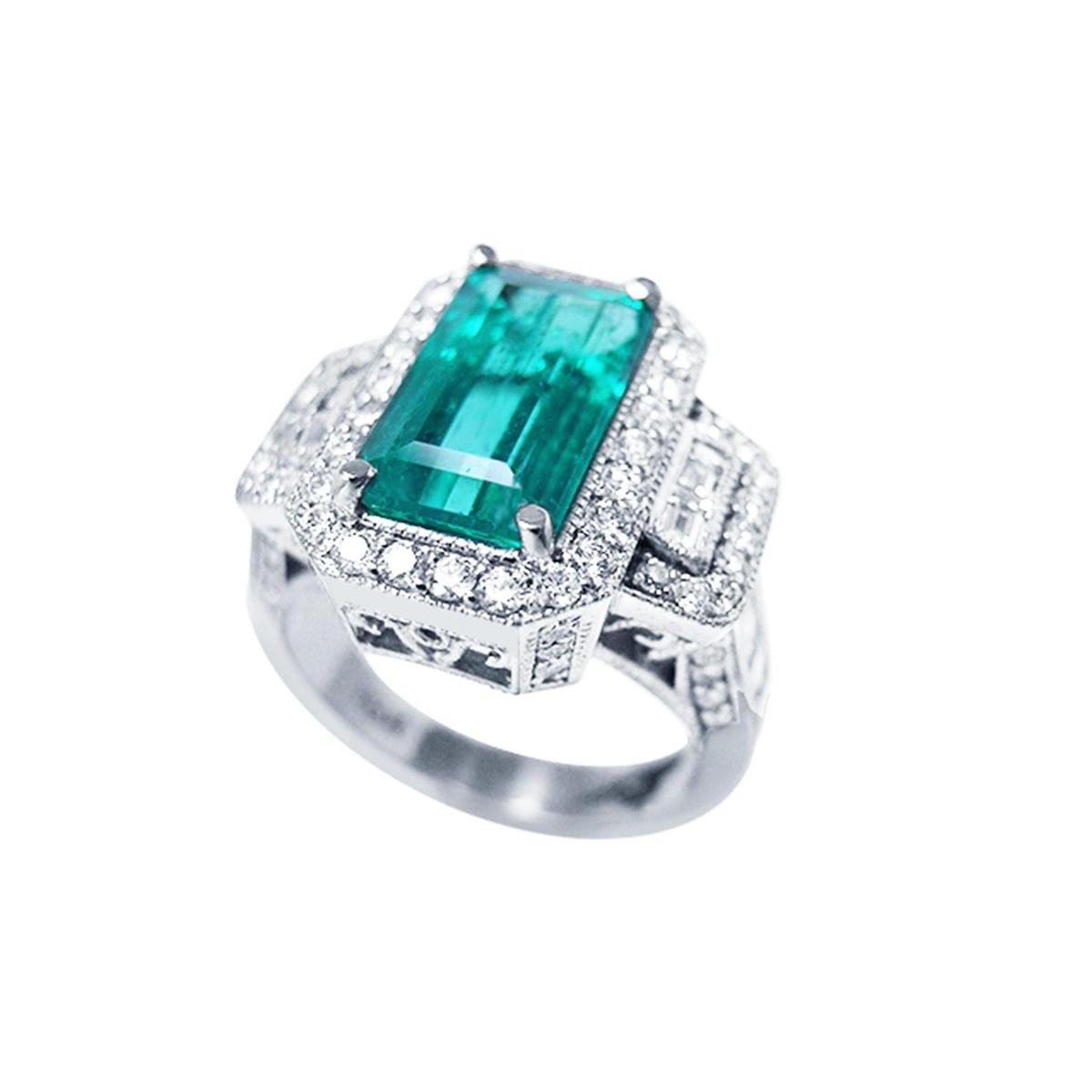 A rectangular emerald with a halo diamond in white gold ring, top side view.