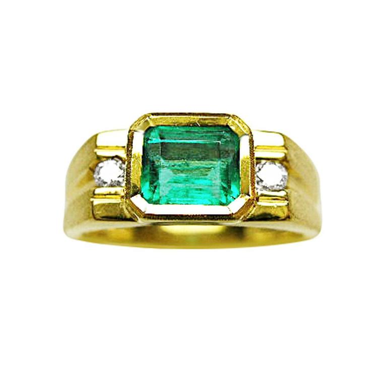 Gold ring for men with a natural emerald and two side diamonds on a topside view position/