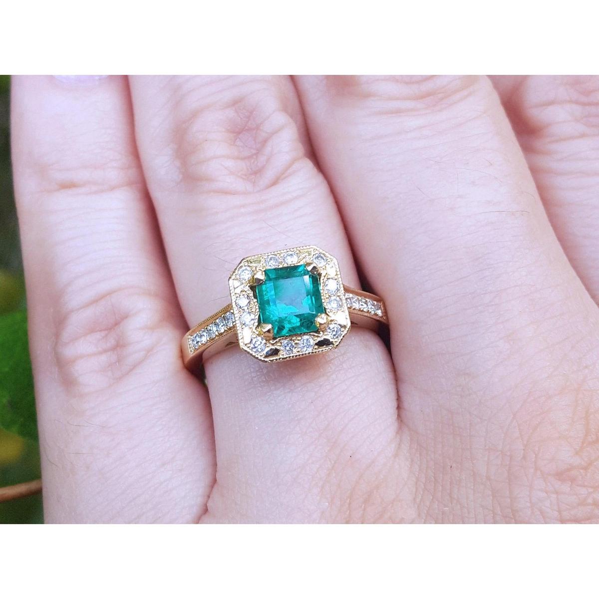 A 14k yellow gold emerald ring on a person's finger.