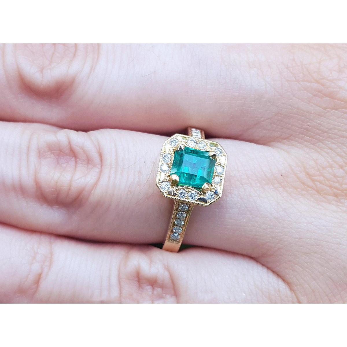 Gold ring with a natural Colombian emerald on a finger.